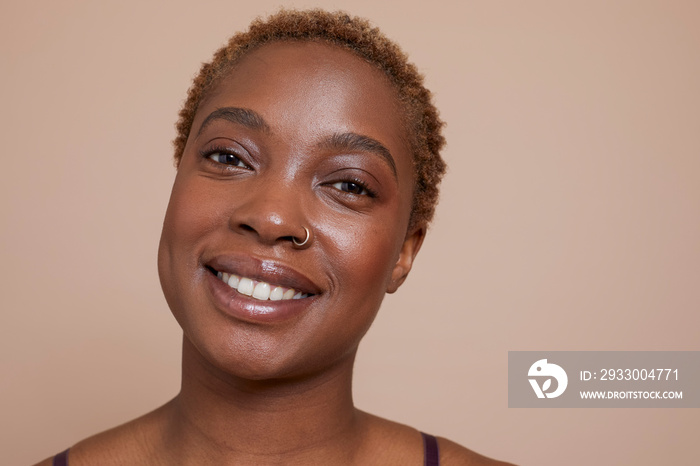 Studio portrait of smiling woman with nose ring