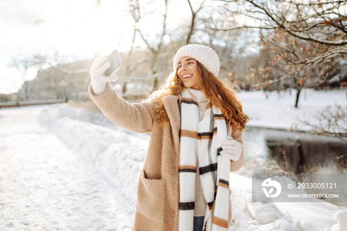 Young woman taking selfie in winter street. Holidays, rest, blogging.