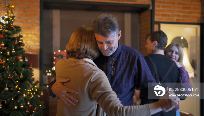 Portrait of a group of Caucasian couples, family, friends, dancing together. They have a celebration dinner in party on Merry Christmas Eve Xmas on holiday at home or house. People lifestyle. Romantic