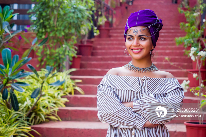 African woman in a dress with a colorful traditional shawl on her head.happy indian female model posing in summer tropical vacation