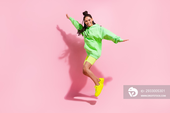 Full body photo of cheerful afro american young woman jump up good mood isolated on pink color background