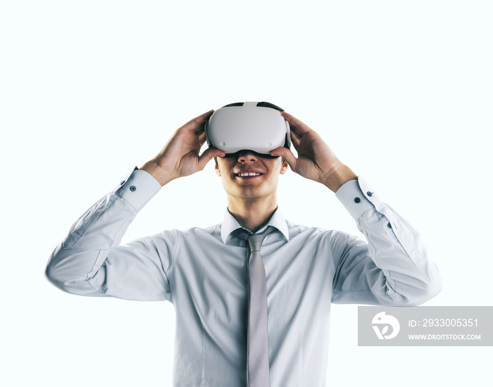 Virtual reality concept with young businessman gets new emotions in VR glasses on his head on abstract white background, close up, isolated