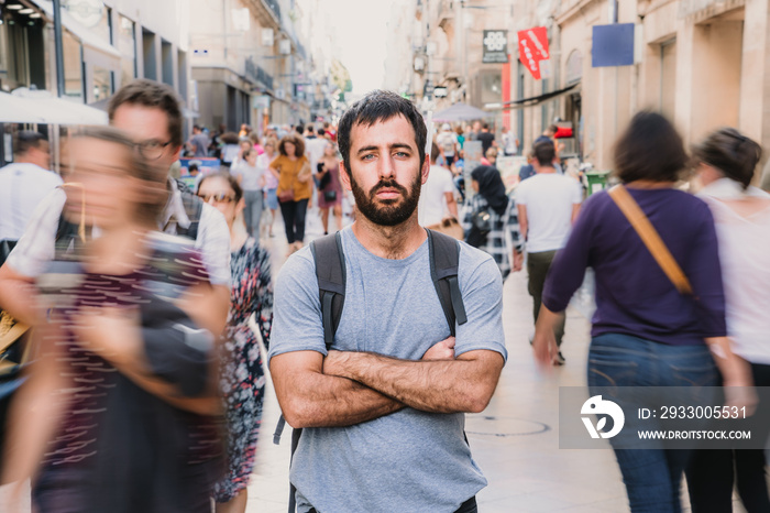 Young and attractive man touring the city of Bordeaux in France. Standing on streets full of people. Lifestyle. Travel photography.