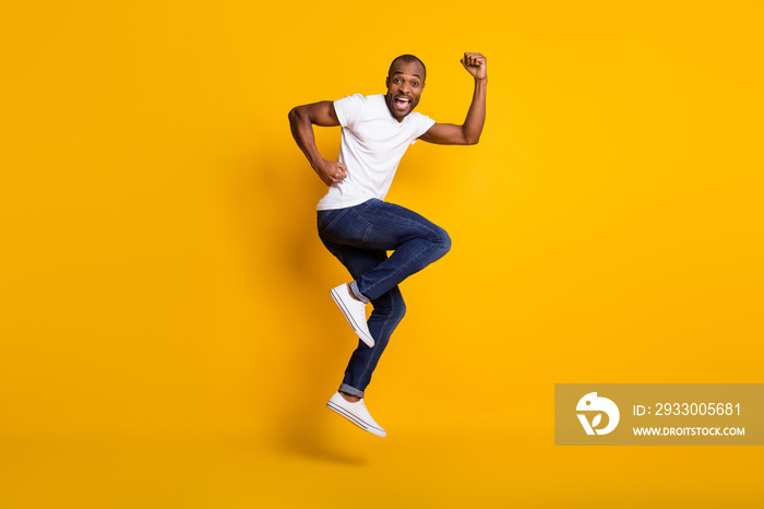 Full length body size view of his he nice attractive glad funny childish cheerful cherry guy jumping having fun dancing isolated over bright vivid shine vibrant yellow color background