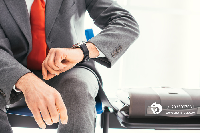 Corporate businessman waiting and checking the time