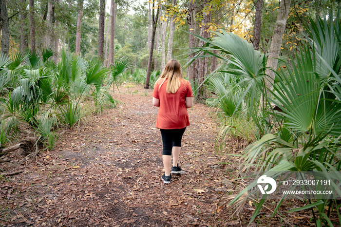 Teen girl walking on a trail in a Florida Park.