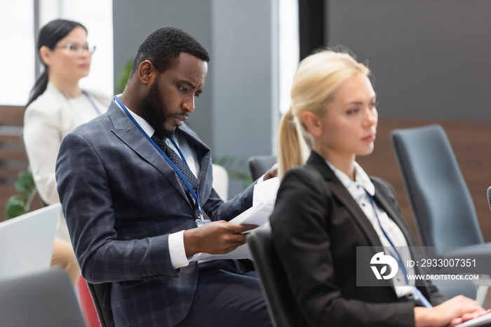 African american businessman looking at documents during business training