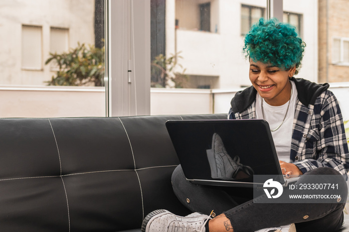 young woman or girl with laptop at home or apartment