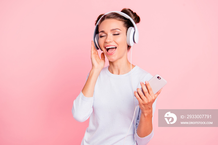 Portrait of nice lovely winsome fascinating attractive cheerful cheery dreamy girl wearing touching earphones closed eyes loud melody isolated over pink pastel background