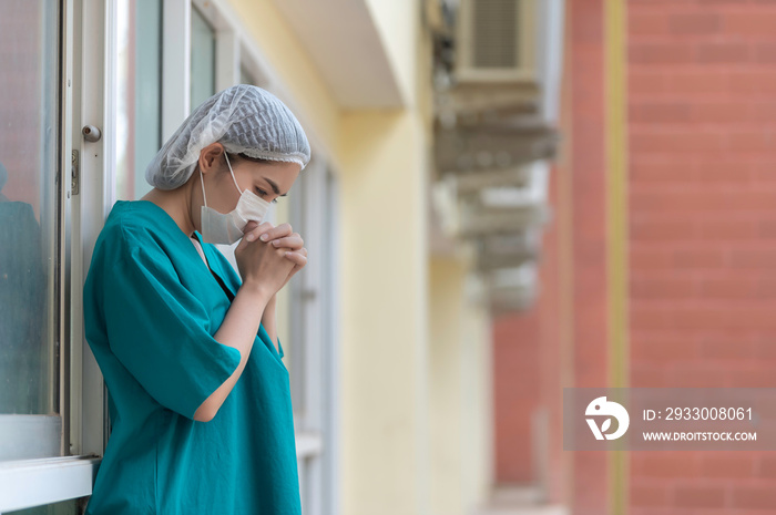 Tired depressed female asian scrub nurse wears face mask blue uniform sits on hospital floor,Young woman doctor stressed from hard work,International nurses day