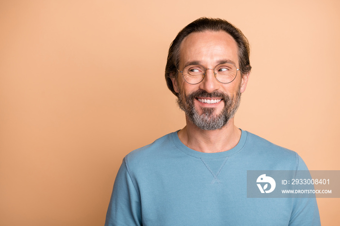 Photo portrait of man looking at blank space isolated on pastel beige colored background