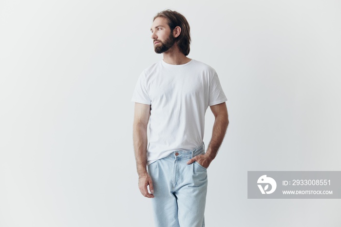 Portrait of a sad man with a black thick beard and long hair in a white t-shirt on a white isolated background