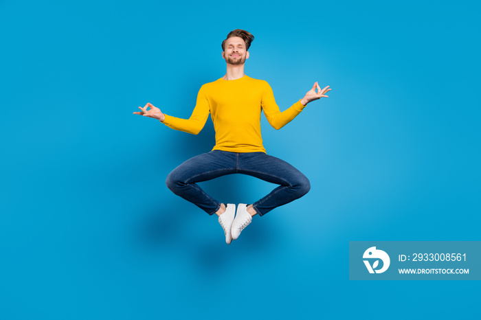 Full length body size of young guy jumping up practising yoga isolated vivid blue color background