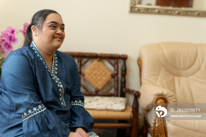 Portrait of young woman with down syndrome at home