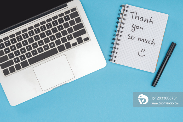 laptop, pen and notebook with thank you so much lettering isolated on blue background