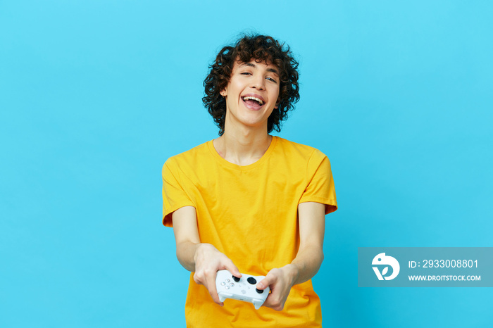 gamer plays with joystick in yellow t-shirts technologies