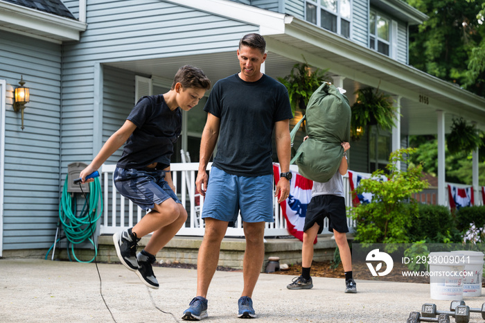 Air Force service member trains with his sons in a morning workout in preperation for a PT fitness test.