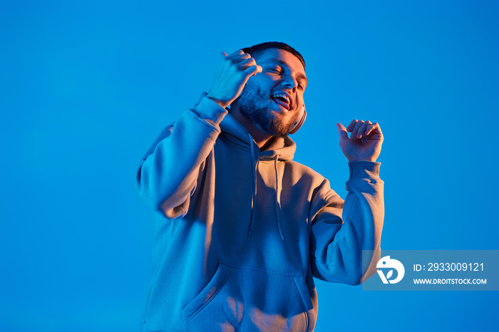 man with headphones in sweatshirt enjoying favorite music