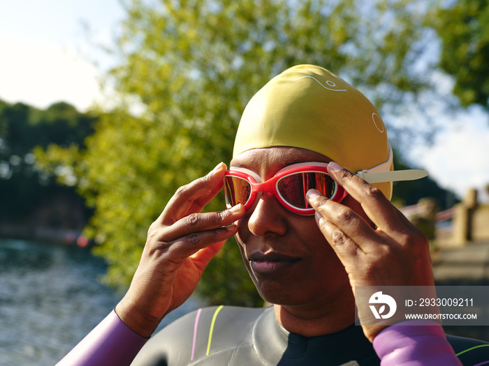 Woman putting on swimming goggles