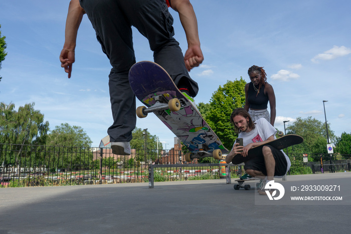 Man recording friend doing skateboard tricks