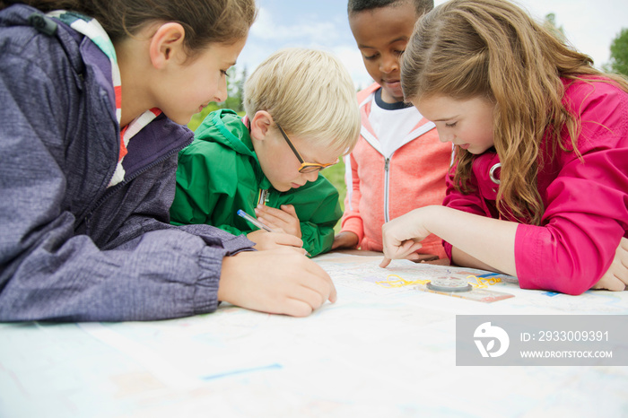 elementary students using navigation tools outdoors