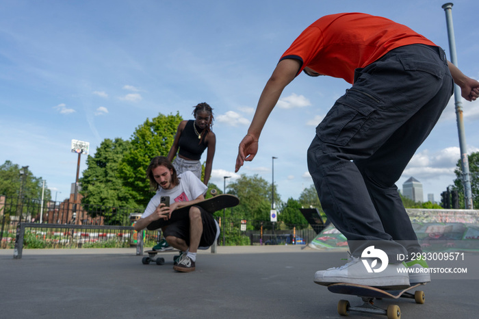 Man recording friend doing skateboard tricks