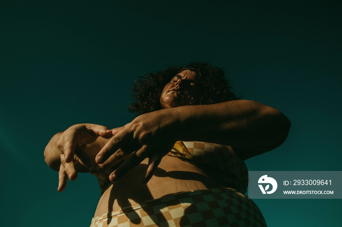 portrait of a plus size woman making a heart shadow on tum