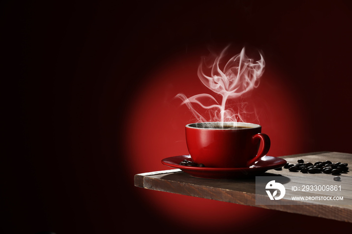 Cup of hot coffee and steam in shape of flower on dark background