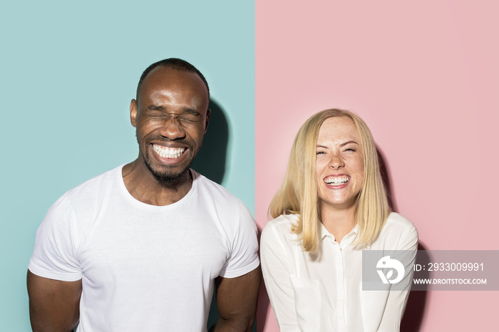 happy afro man and woman. Dynamic image of caucasian female and afro male model on pink studio.