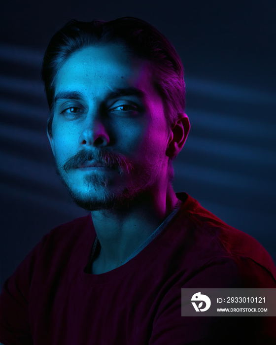 Beautiful caucasian young man portrait isolated on multicolored neon light backgroud. Human emotions, facial expression concept. Trendy colors. Advertising concept