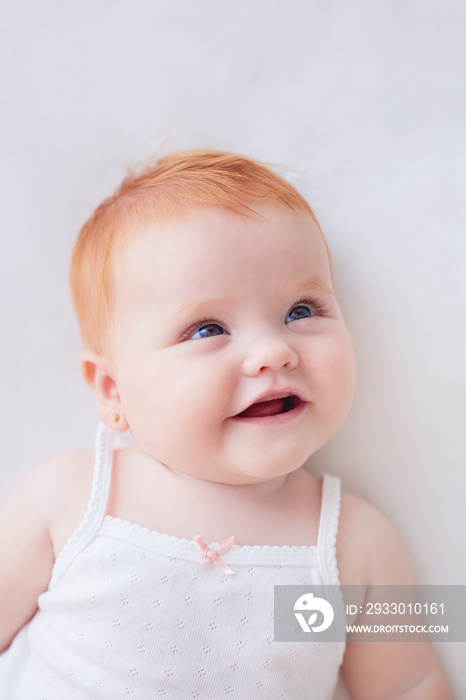 portrait of cute smiling baby girl with red hair