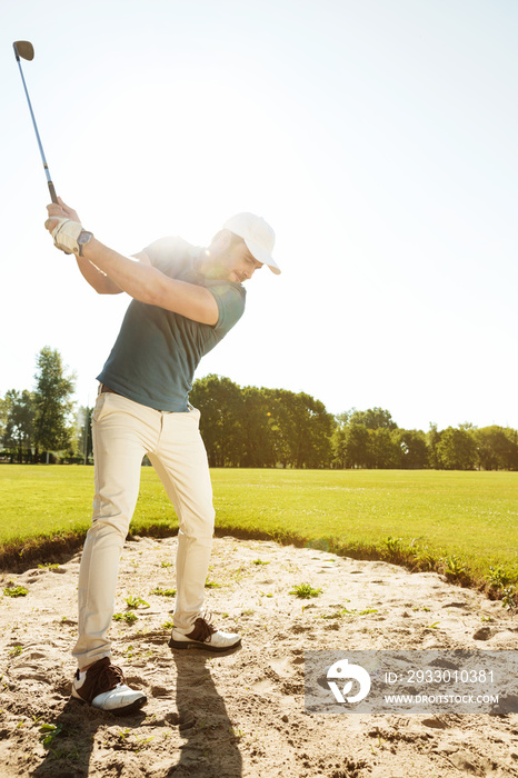 Golfer about to hit ball out of a sand bunker