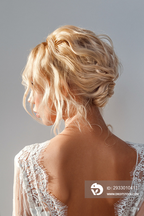 Rear view portrait of attractive young woman with beautiful wedding hairstyle and dress