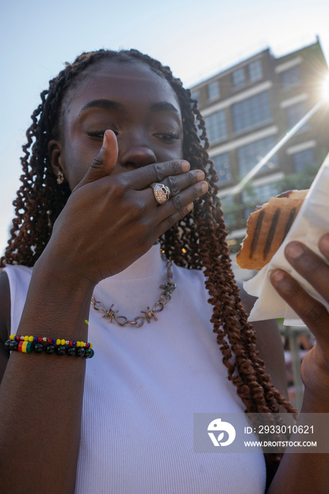 Young woman eating hot dog