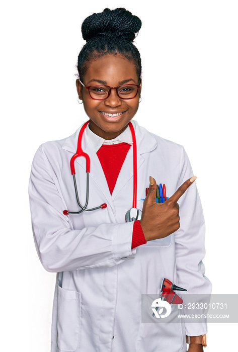 Young african american woman wearing doctor uniform and stethoscope cheerful with a smile on face pointing with hand and finger up to the side with happy and natural expression