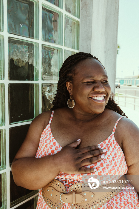 African American woman looks way hand on chest