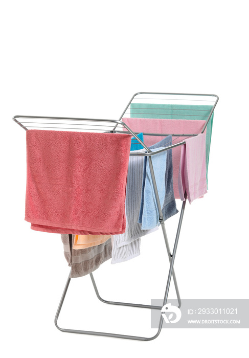 Clothes dryer with clean towels on white background