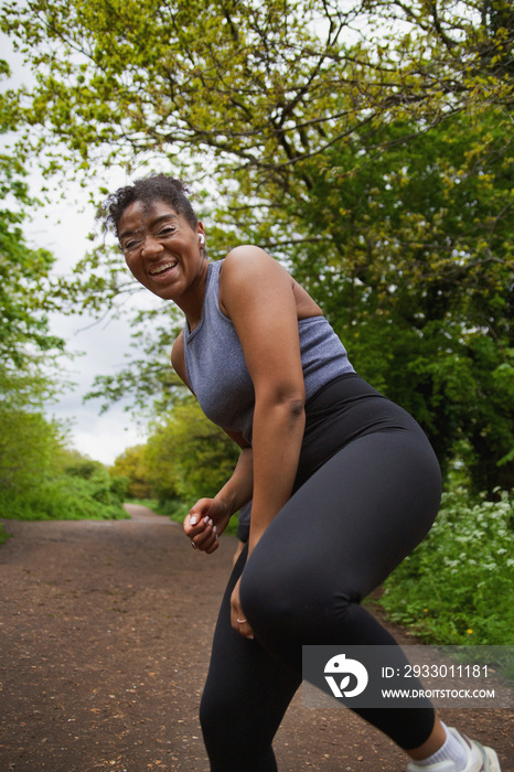 Young curvy woman with vitiligo working out in the park wearing earbuds