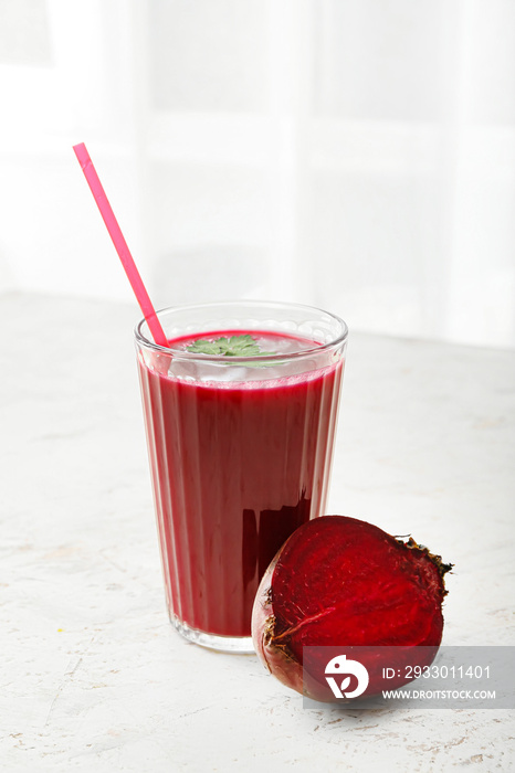 Glass of healthy smoothie with beetroot on light background