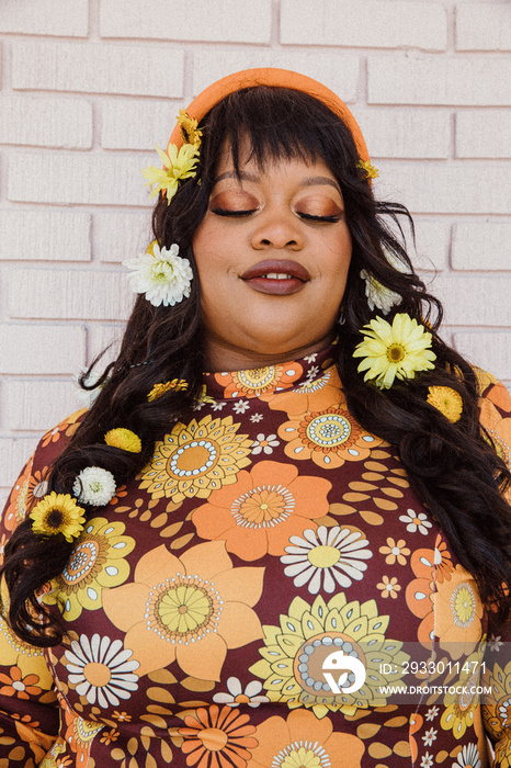closeup of plus size Black woman with flowers in hair and eyes closed
