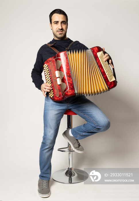 young man playing accordion on the white background