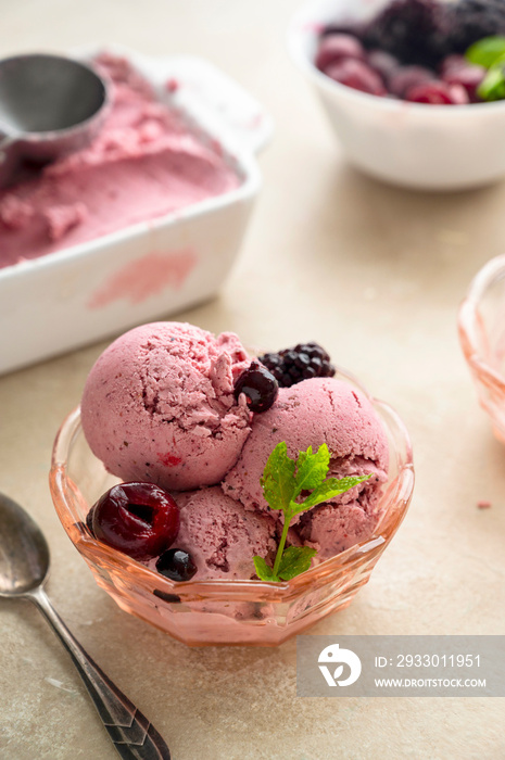 Pink ice cream scoops in glass bowl, close up. Homemade healthy sorbet with banana and berry, icecream refresing treat