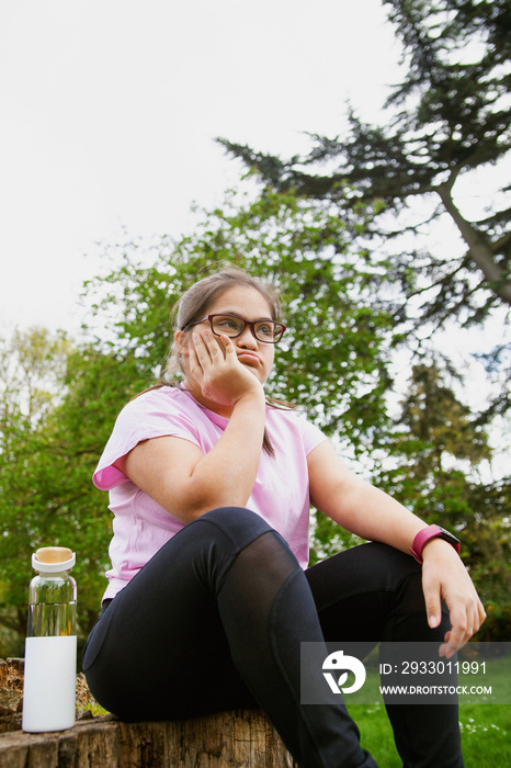 Young curvy girl with Down Syndrome relaxing after workout