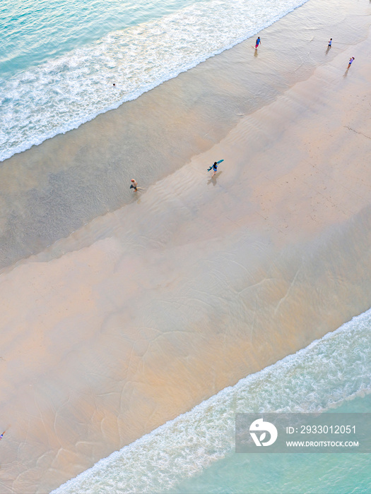 Conceptual two waves float into middle of the sand beach center. It’s top view flatlay aerial seascape with stunning beautiful turquoise sea landscape.