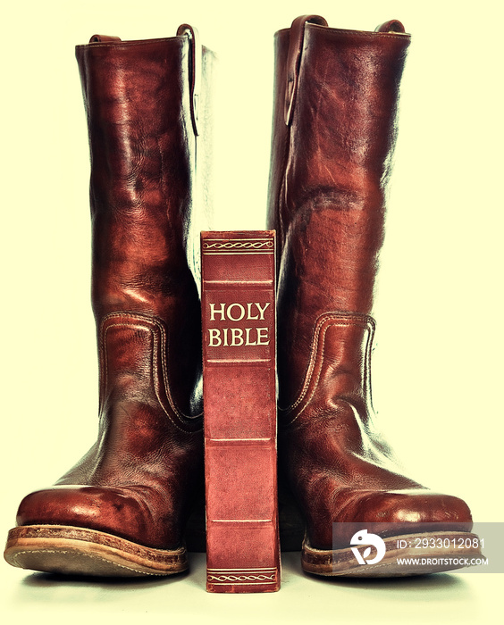 Bible and boots on gray background