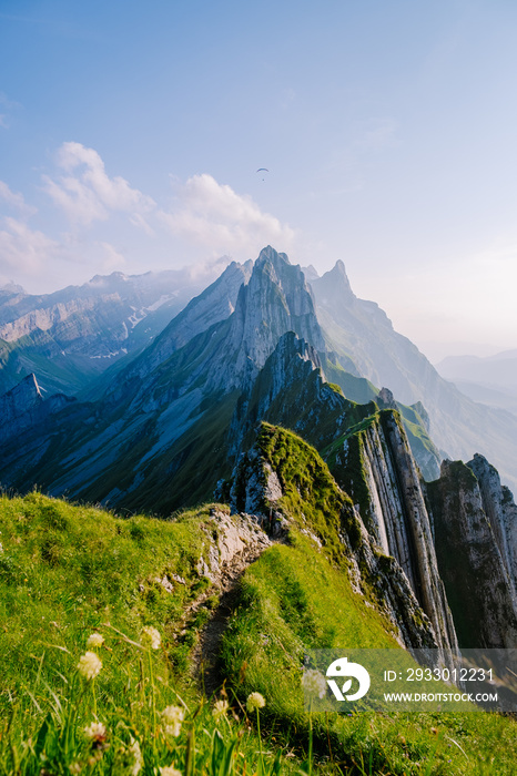 Schaefler Switzerland, a couple walking hiking in mountains during sunset, man and woman sunset at the Ridge of the majestic Schaefler peak in the Alpstein mountain range Appenzell,