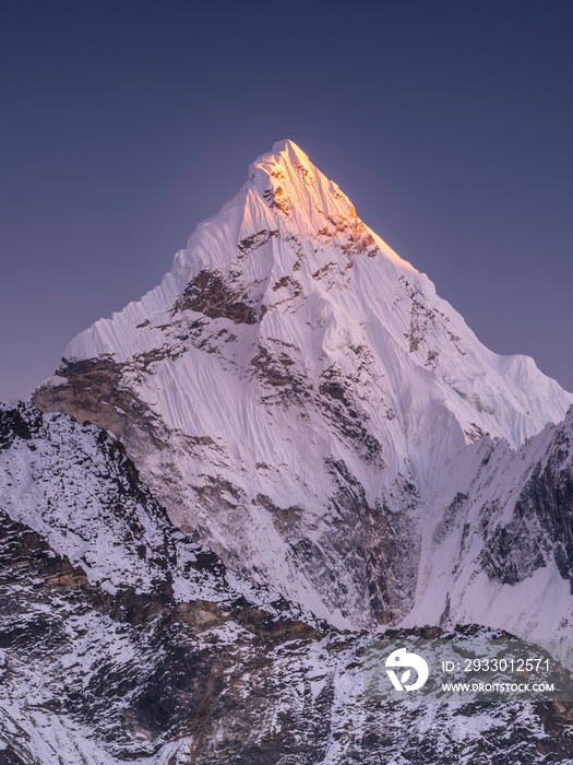 Triangle snow peak in last sun light under dark blue sky in Nepal