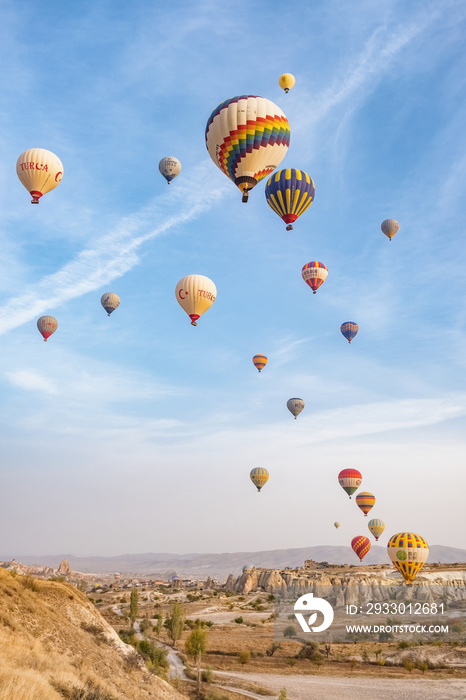 Hot air balloon flying over famous rock formations landscape of Cappadocia, Turkey