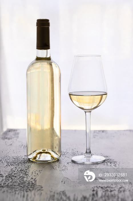 Wine bottle with  White wine  glass on the black background. Luxury wine tasting concept.