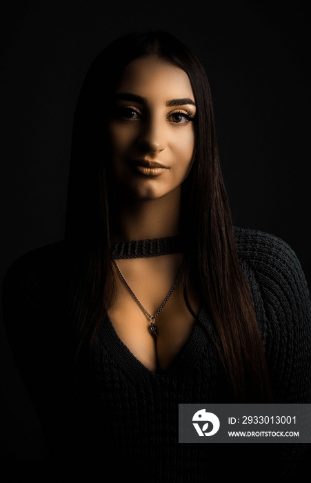 Studio portrait of a young beautiful girl of twenty years old, in warm colors of artistic retouching, against the backdrop of old